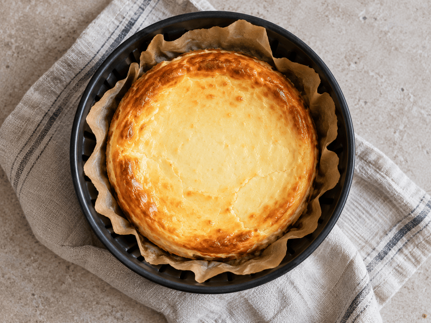 Cremiger High-Protein Käsekuchen frisch aus dem Airfryer, angerichtet auf einem Teller mit Beeren