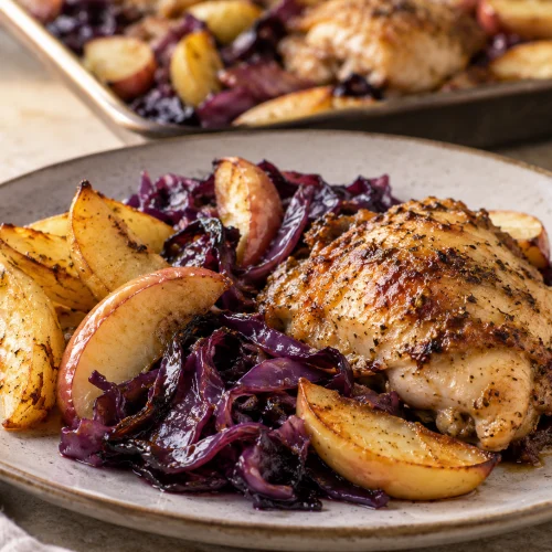 Meal-Prep Hähnchen-Rotkohl-Blech mit Kartoffeln und Apfel auf einem Backblech frisch gebacken