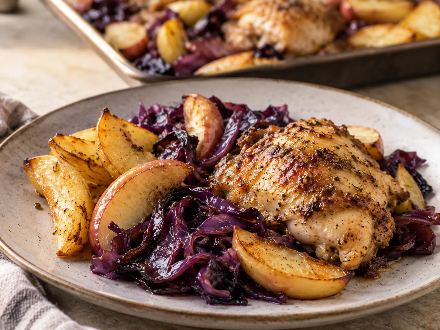 Meal-Prep Hähnchen-Rotkohl-Blech mit Kartoffeln und Apfel auf einem Backblech frisch gebacken